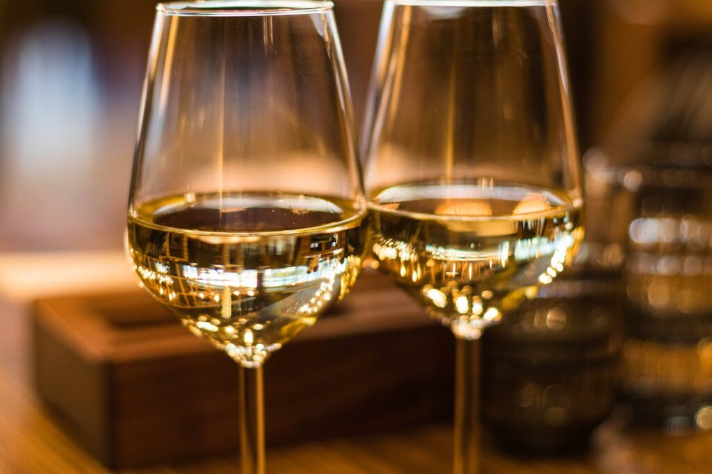 pexels-photo-1123260 Two elegant wine glasses filled with white wine, captured with a beautiful bokeh effect.