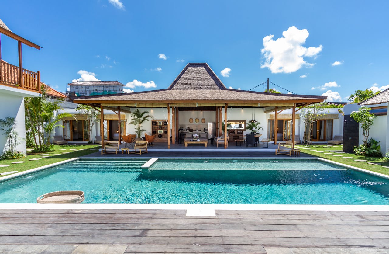 Elegant tropical villa featuring a serene swimming pool and lush garden, ideal for a luxury retreat.