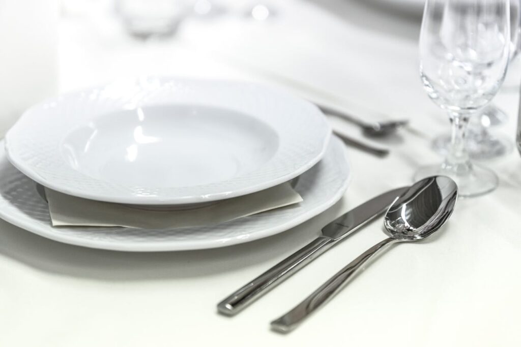pexels-photo-291767 Elegant dining table with white porcelain plates and silver cutlery elegantly arranged.